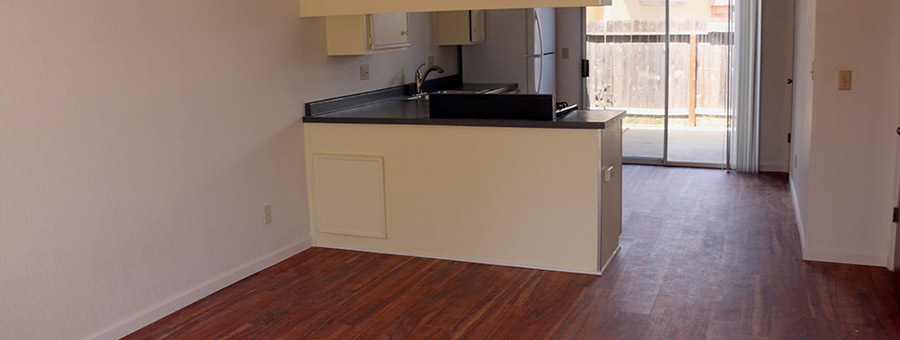 Living room with open kitchen, pantry, small patio, half-bath, and extra storage under the stairs.